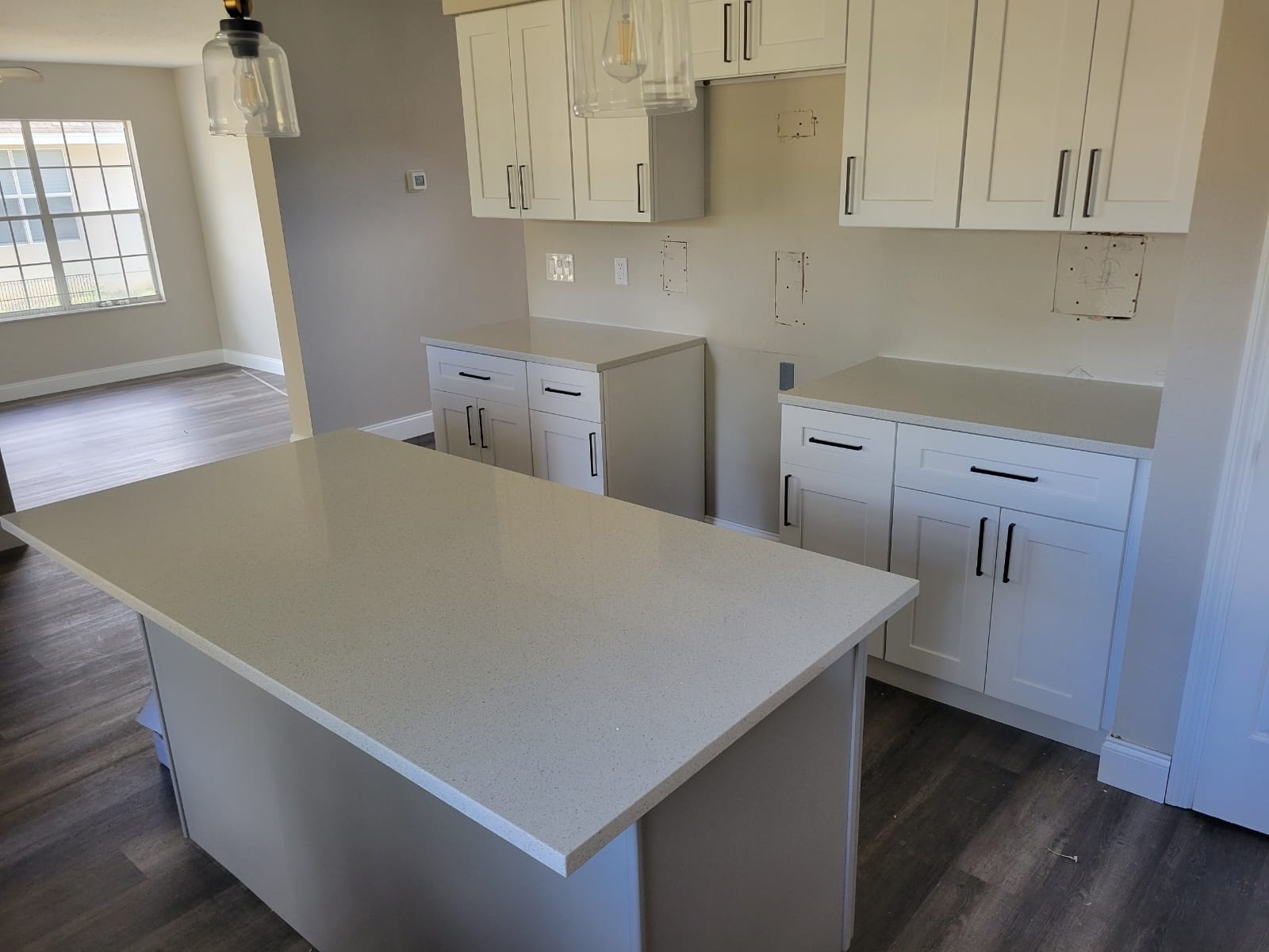 White shaker kitchen under construction with quartz island by 1 Stop Cabinets